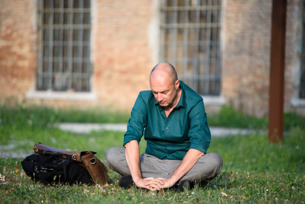 Klaas zit buiten op het gras