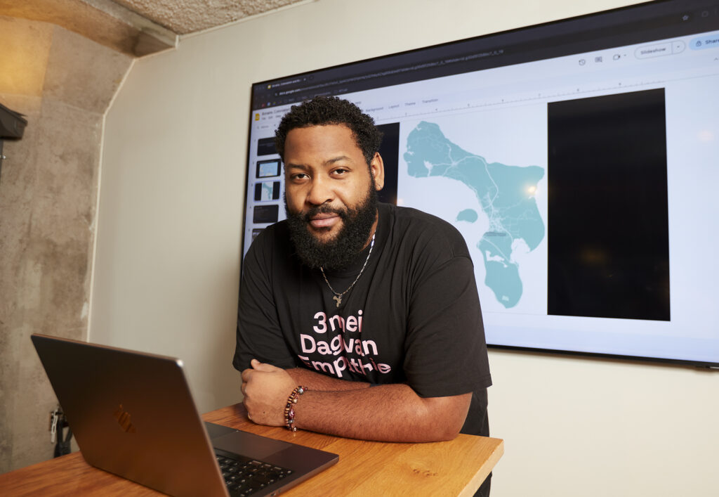 Kjelld Kroon zit aan een bureau, voor een landkaart van Bonaire