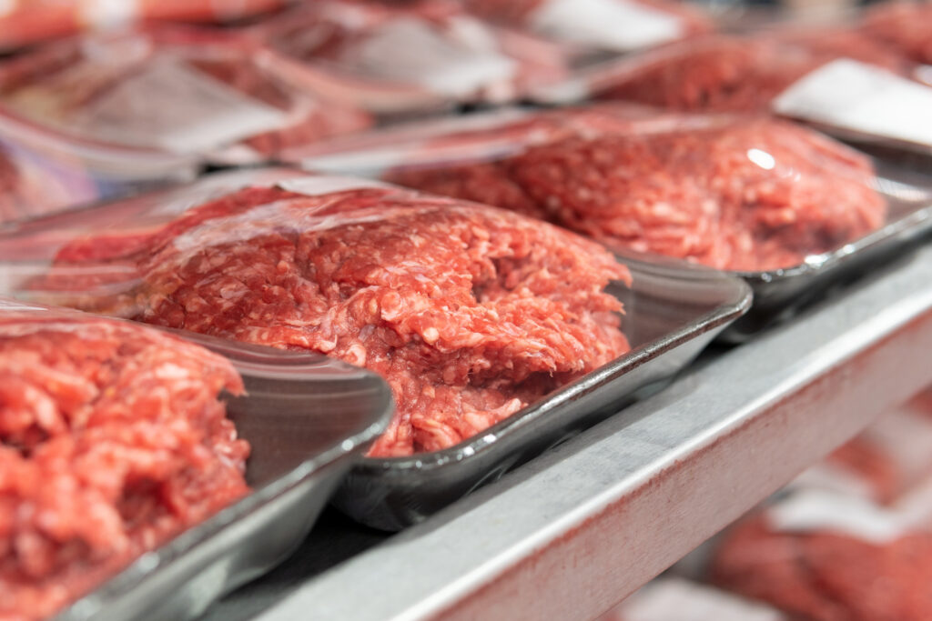 Pakjes verpakt hamburger vlees in een supermarkt schap. 